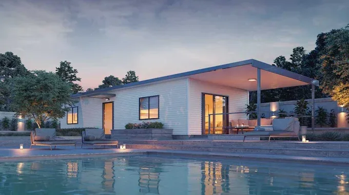 Modern home lit at dusk beside a swimming pool